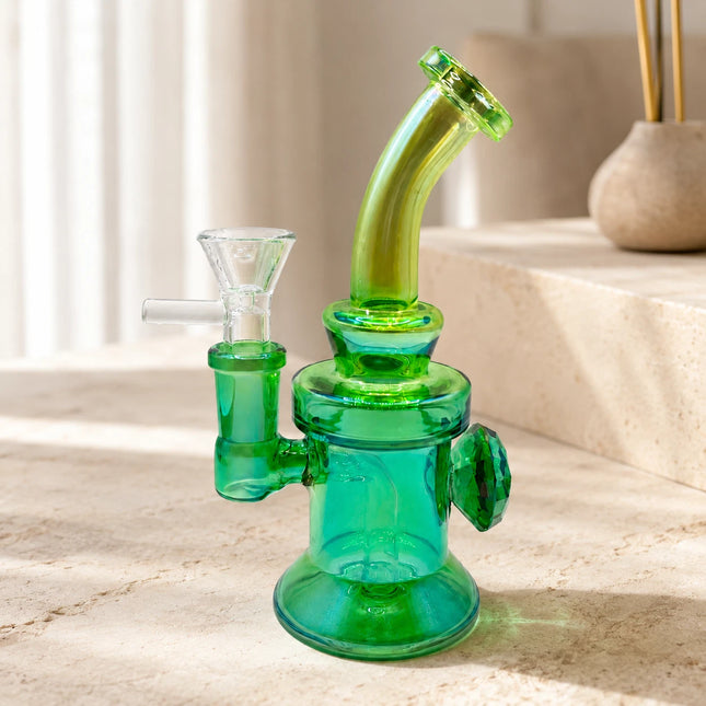 Emerald green chrome mini water pipe displayed on a bright neutral tabletop with a curved lime mouthpiece and compact rounded base