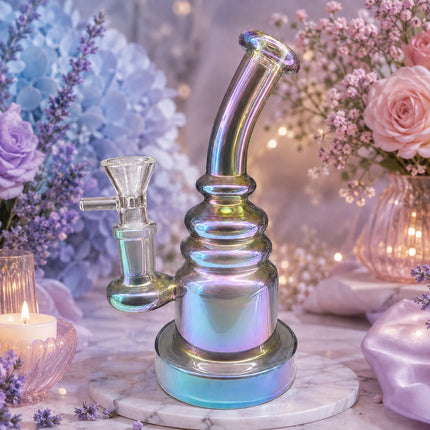 Crystal chrome iridescent bent neck bong displayed in a dreamy pastel floral setting with lavender and pink flowers