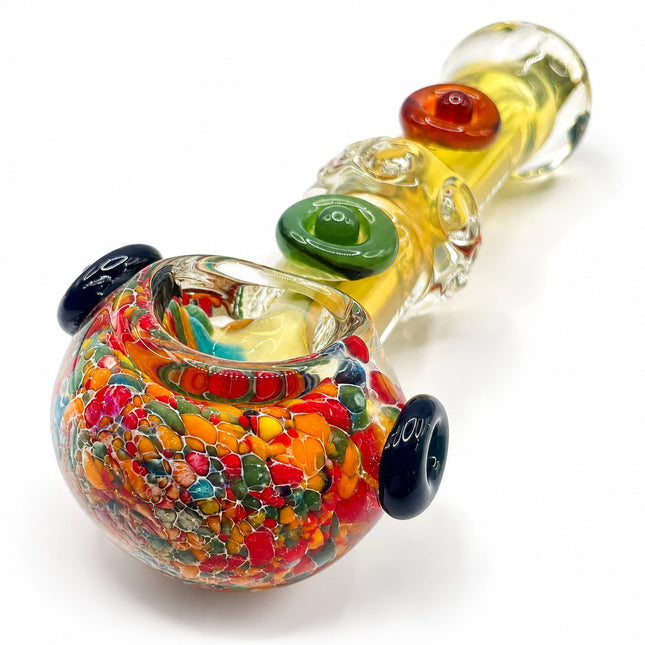 Picasso-style clear fumed spoon pipe with colorful speckled bowl, amber stem, and raised glass marbles on a white background