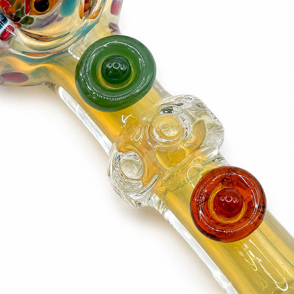 Macro view of the stem showing green and orange decorative marbles embedded along the clear fumed glass