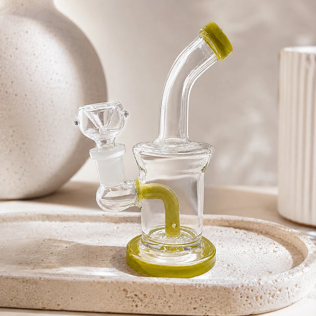 Clear mini glass water pipe with lime accents displayed on a neutral tabletop in soft natural light