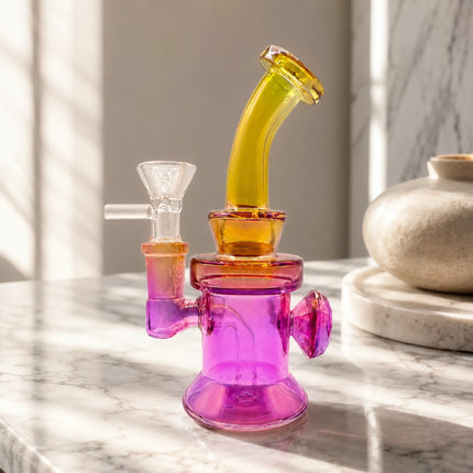 Pink and yellow chrome mini glass bong with a 14mm bowl displayed on a neutral tabletop with soft natural lighting