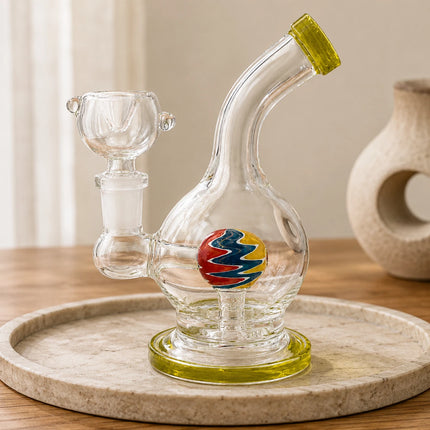 Moss green orb perc mini round glass bong styled on a neutral tabletop with soft decor and warm natural lighting