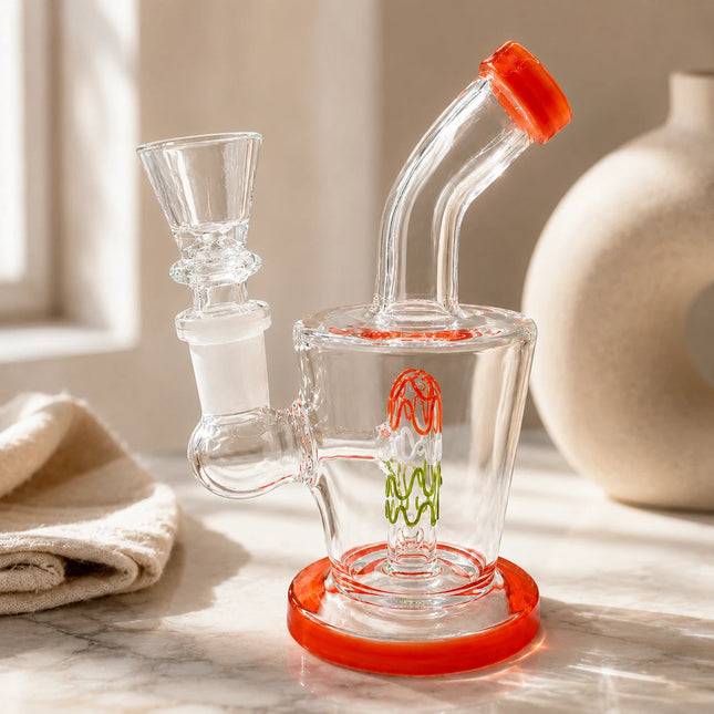 Orange squiggle perc mini water pipe displayed on a warm neutral tabletop with soft natural light and minimal decor