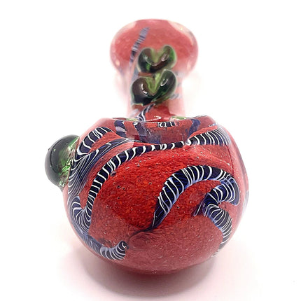 Top-down close view of the spoon pipe bowl showing the deep red glass chamber and green textured bead details near the neck