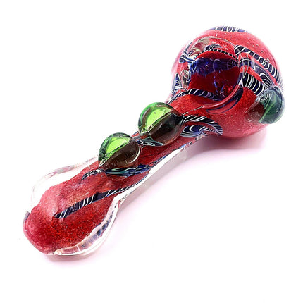 Red and green swirl glass spoon pipe displayed at an angle on a clean white background with decorative raised accents along the handle