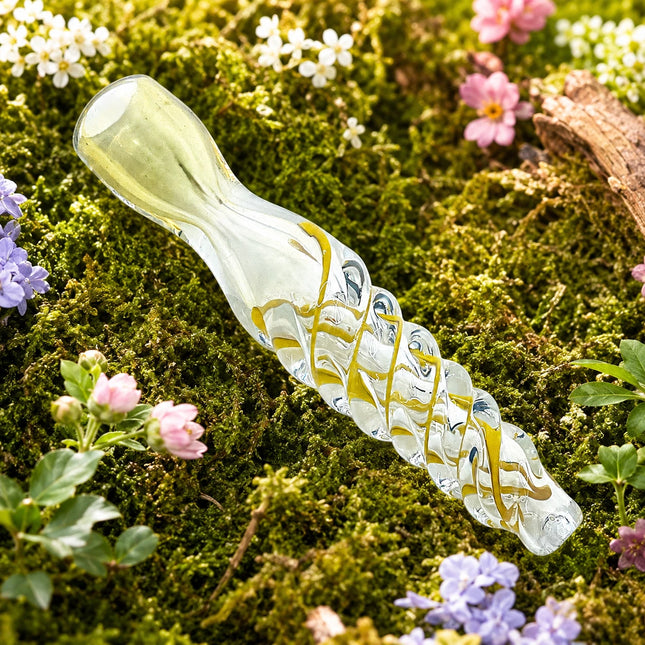 Clear chillum with golden crisscross ribbon accents displayed across soft moss and tiny spring flowers.