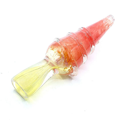 Angled view of a coral pink ribbed chillum pipe showing the tapered body and soft yellow mouthpiece on a clean neutral backdrop.